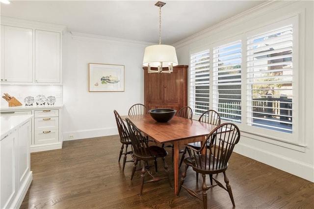 dining space featuring baseboards, dark wood-type flooring, and crown molding