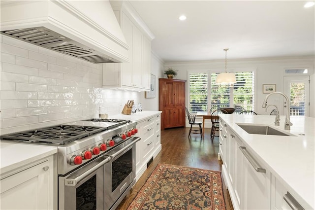 kitchen with range with two ovens, ornamental molding, dark wood-type flooring, custom exhaust hood, and a sink