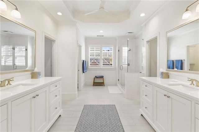 full bath with a tray ceiling, a sink, and crown molding