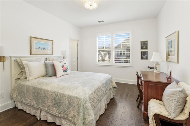 bedroom with baseboards, visible vents, and dark wood finished floors