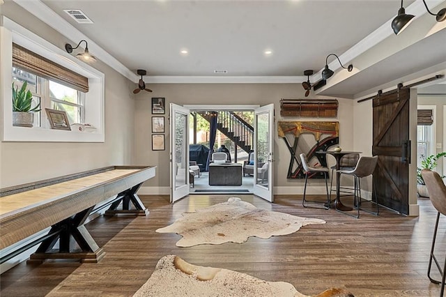 workout room with ornamental molding, visible vents, plenty of natural light, and a barn door