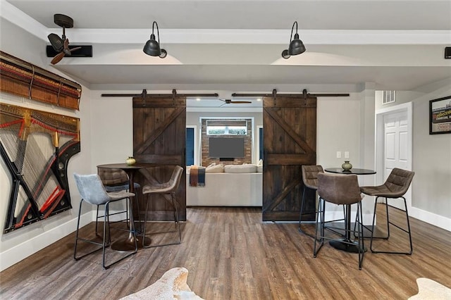 bar with baseboards, a barn door, visible vents, and wood finished floors