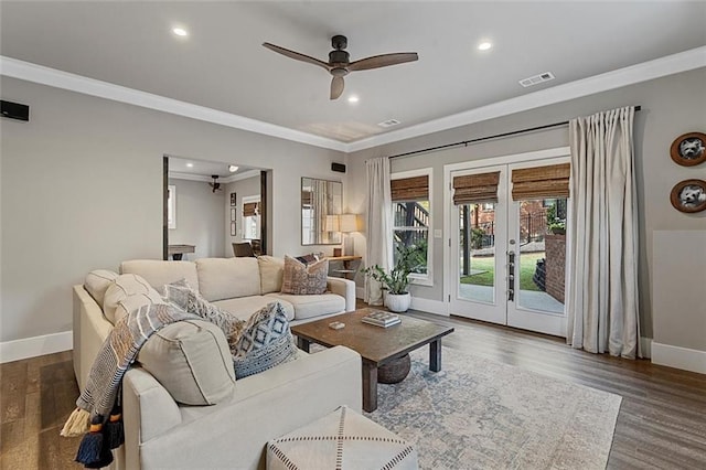 living room with wood finished floors, visible vents, baseboards, french doors, and crown molding