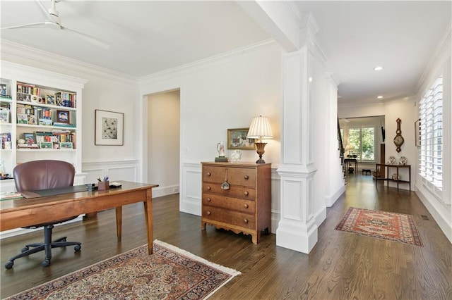 home office featuring crown molding, a decorative wall, ornate columns, and wood finished floors