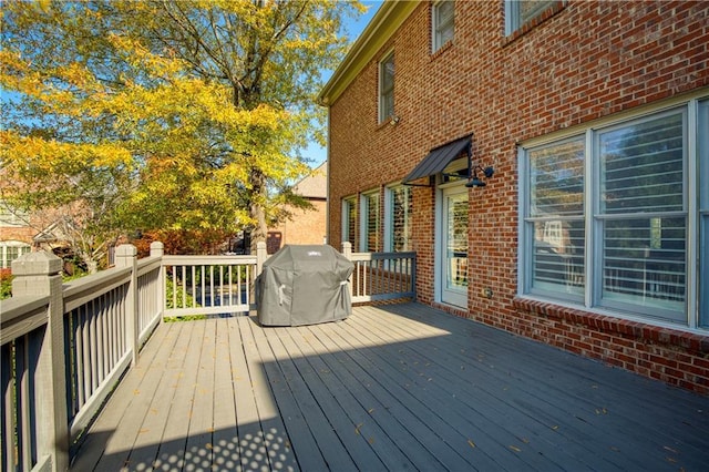 wooden deck featuring a grill