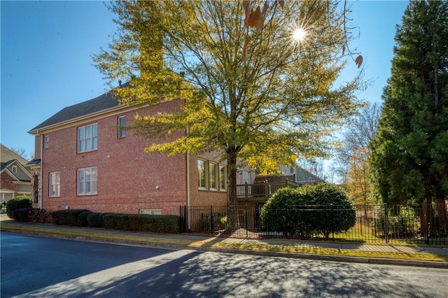 view of property exterior with brick siding and a fenced front yard