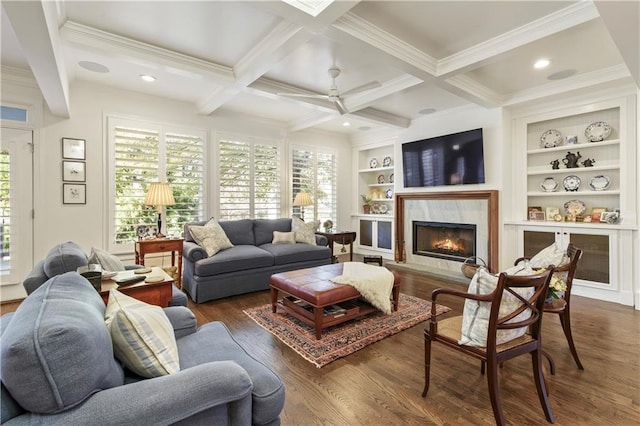 living room with built in features, coffered ceiling, wood finished floors, a fireplace, and beam ceiling