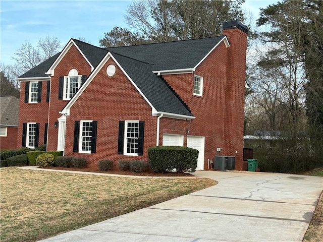 view of front facade with a garage, a front lawn, and central air condition unit