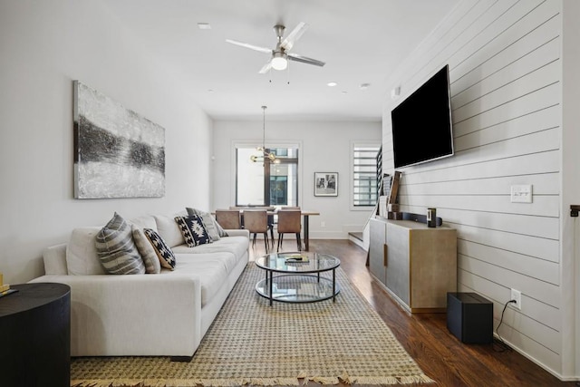 living room with ceiling fan and dark hardwood / wood-style flooring