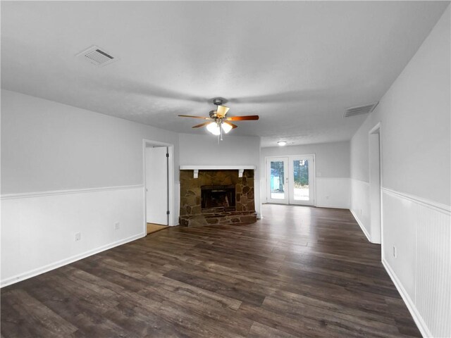 unfurnished living room featuring dark hardwood / wood-style flooring, ceiling fan, french doors, and a fireplace