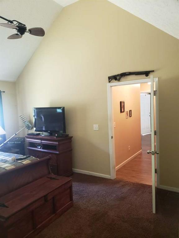 1383 Sims Rd, Winder, GA 30680 - carpeted living room featuring ceiling fan, baseboards, and high vaulted ceiling