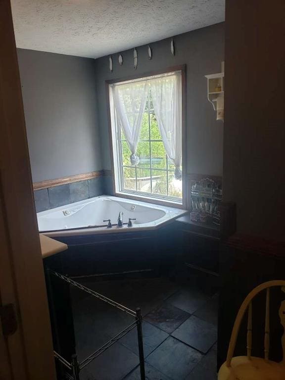 1383 Sims Rd, Winder, GA 30680 - full bath with a textured ceiling, a whirlpool tub, and tile patterned floors