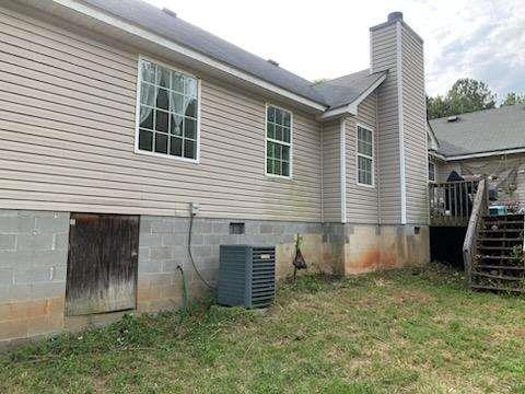 1383 Sims Rd, Winder, GA 30680 - view of home's exterior featuring a chimney, a yard, a wooden deck, and central air condition unit