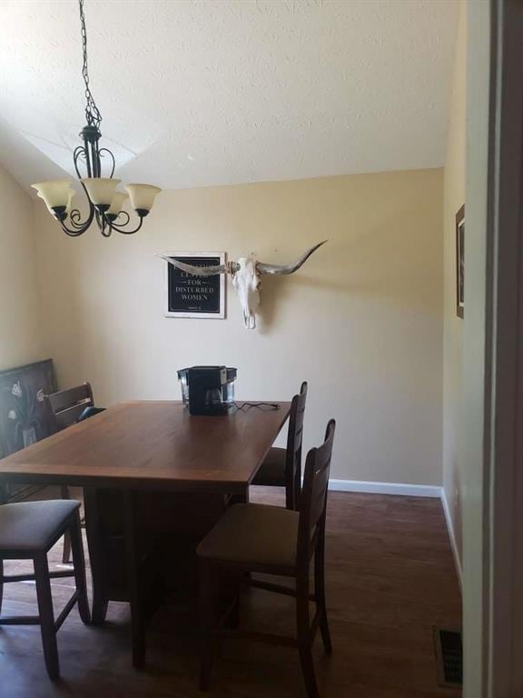 1383 Sims Rd, Winder, GA 30680 - dining room featuring a textured ceiling, a chandelier, baseboards, and dark wood-style flooring