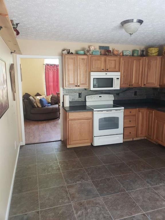 1383 Sims Rd, Winder, GA 30680 - kitchen with white appliances, a textured ceiling, dark countertops, backsplash, and baseboards