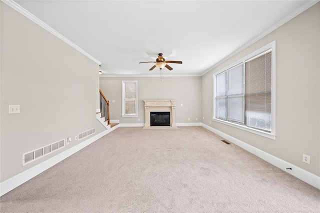 unfurnished living room with ornamental molding, ceiling fan, and carpet floors