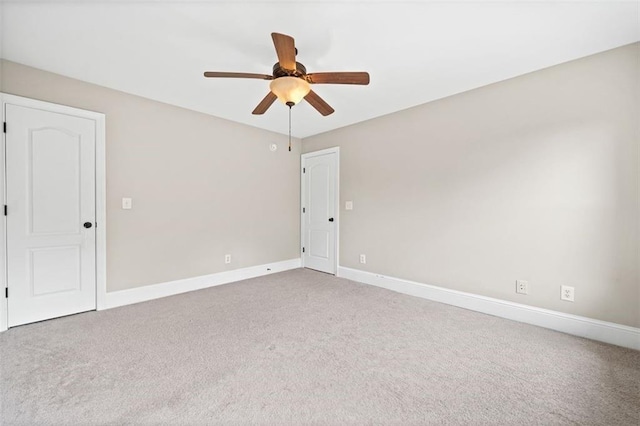 carpeted spare room featuring ceiling fan