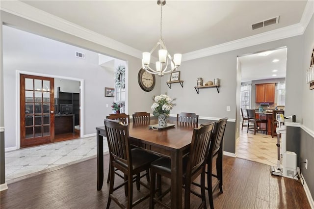 dining room with visible vents, dark wood finished floors, and ornamental molding