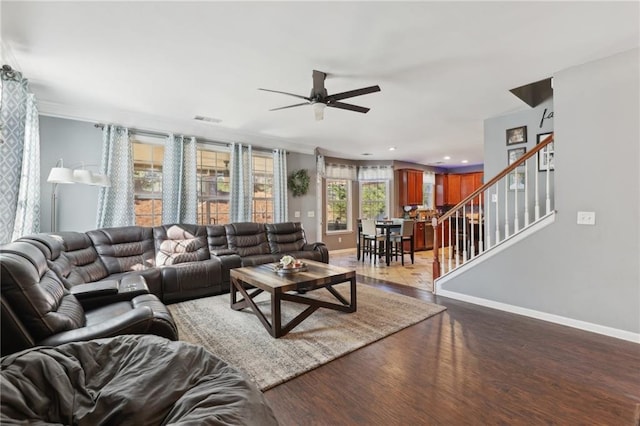 living room featuring stairs, wood finished floors, visible vents, and baseboards