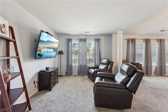 living area with light carpet, decorative columns, visible vents, and baseboards