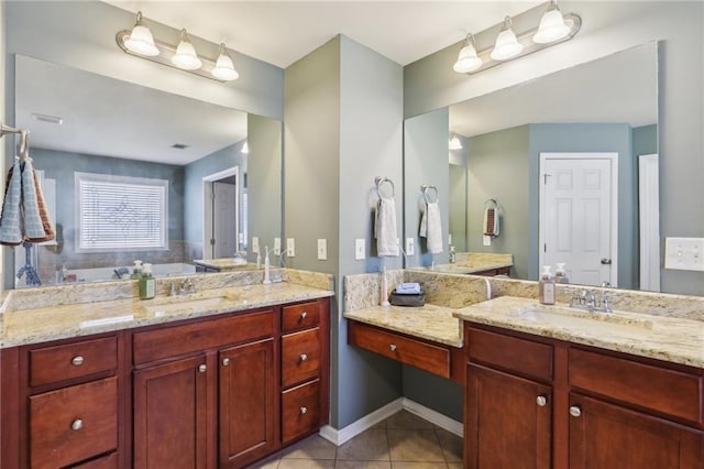 bathroom featuring baseboards, visible vents, tile patterned flooring, vanity, and a bath