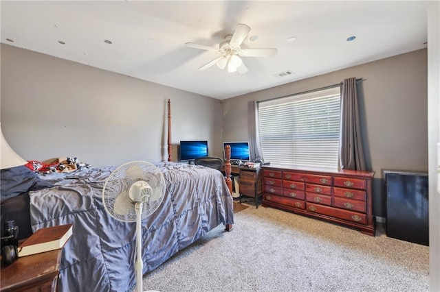 carpeted bedroom with a ceiling fan and visible vents