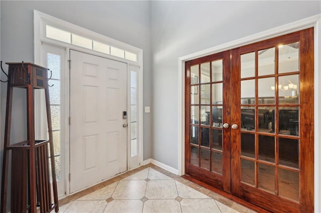 entryway featuring light tile patterned floors, baseboards, and french doors