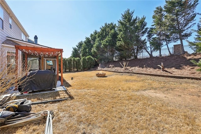 view of yard featuring a fire pit and fence