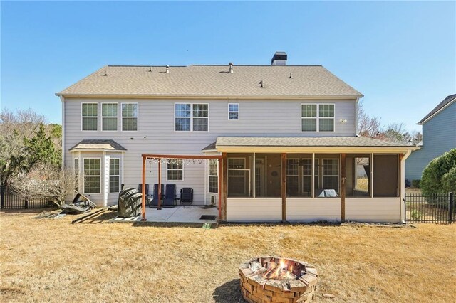 back of house featuring a fire pit, fence, a sunroom, a yard, and a patio area