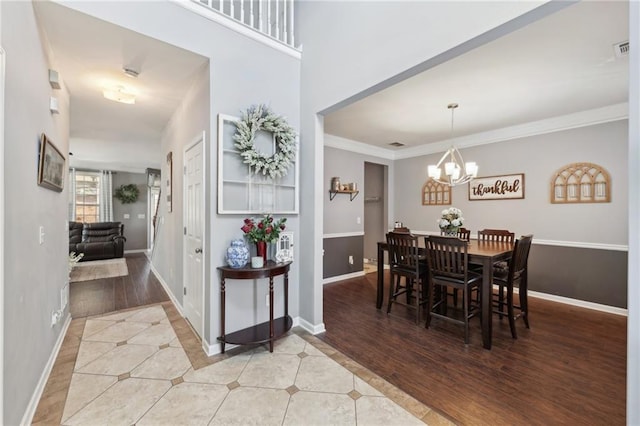 tiled dining room with baseboards, an inviting chandelier, visible vents, and crown molding