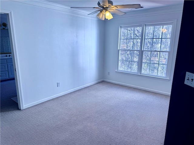 carpeted spare room featuring ceiling fan and crown molding