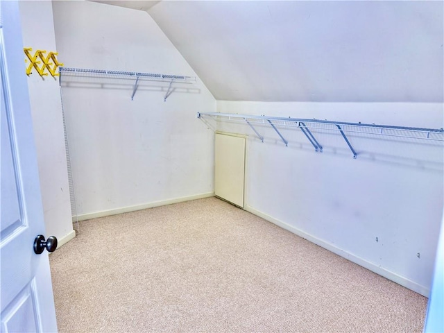 walk in closet featuring light carpet and lofted ceiling