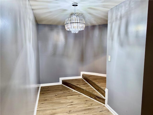 stairway with a chandelier and hardwood / wood-style floors