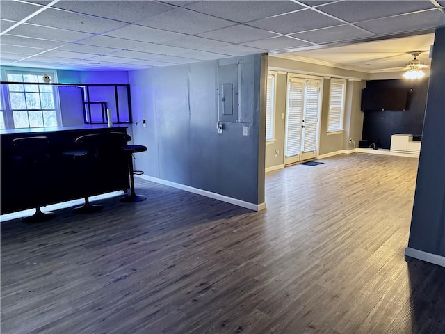 interior space featuring wood-type flooring, electric panel, a drop ceiling, and ceiling fan