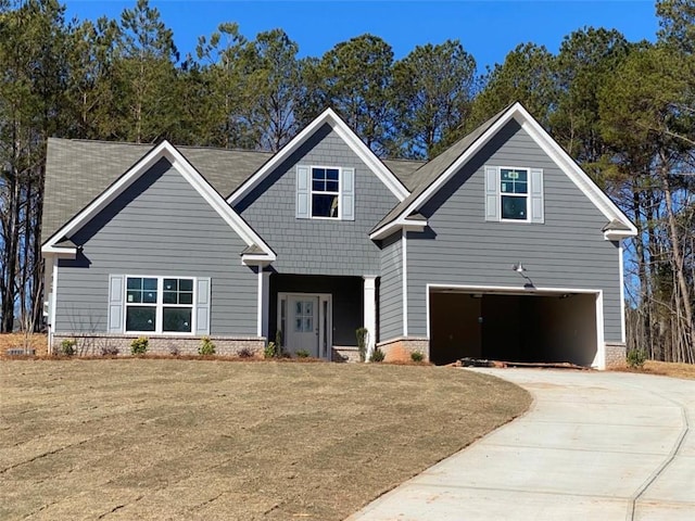 view of front facade featuring an attached garage, driveway, and a front yard