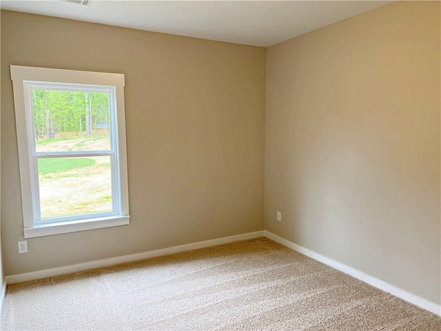empty room with baseboards, carpet flooring, and visible vents
