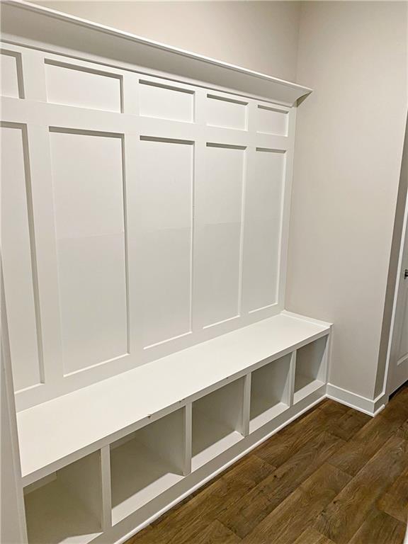 mudroom featuring baseboards and dark wood-type flooring
