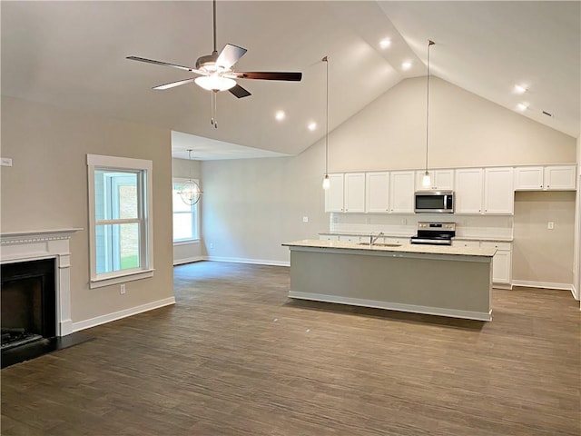 kitchen featuring a sink, stainless steel appliances, white cabinetry, and open floor plan