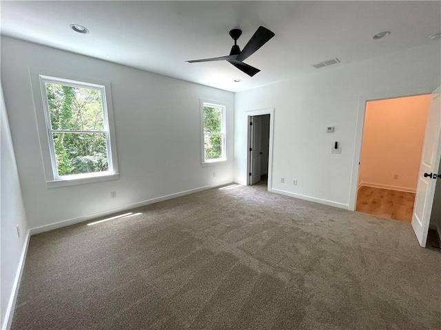 unfurnished bedroom featuring ceiling fan, carpet, and multiple windows