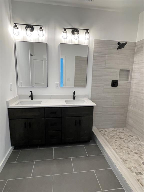 bathroom with vanity, tile patterned flooring, and tiled shower