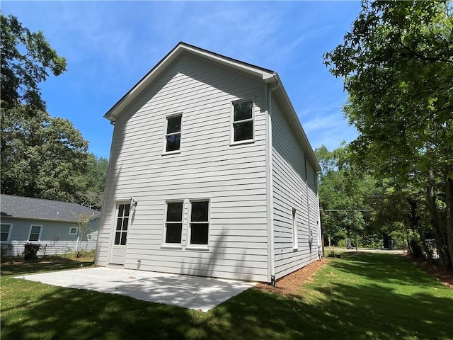 rear view of house with a yard and a patio area