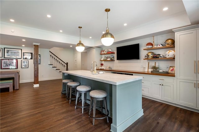 4823 Layfield Dr, Dunwoody, GA 30338 - kitchen featuring open shelves, dark wood-type flooring, ornamental molding, a kitchen bar, and a sink