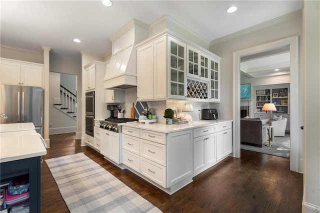 4823 Layfield Dr, Dunwoody, GA 30338 - kitchen featuring appliances with stainless steel finishes, decorative backsplash, crown molding, glass insert cabinets, and recessed lighting