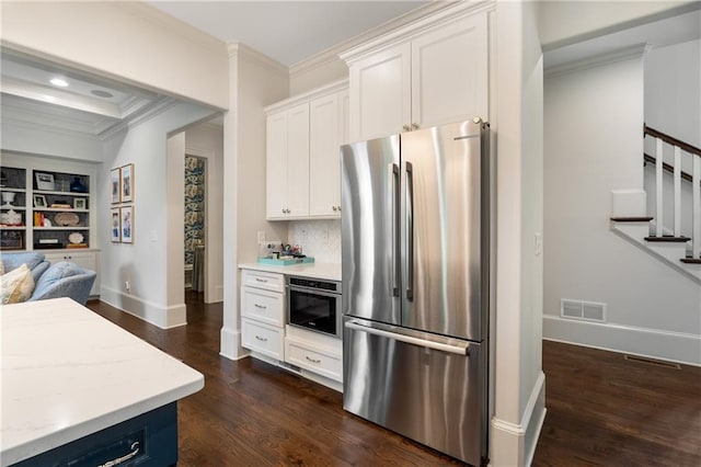 4823 Layfield Dr, Dunwoody, GA 30338 - kitchen with freestanding refrigerator, ornamental molding, dark wood finished floors, baseboards, and white cabinetry