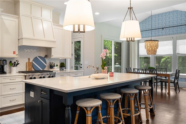 4823 Layfield Dr, Dunwoody, GA 30338 - kitchen featuring a kitchen island, light countertops, dark wood-style floors, white cabinetry, and backsplash