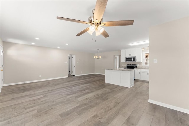1292 Fernside Dr, Toccoa, GA 30577 - unfurnished living room with a chandelier, a ceiling fan, baseboards, light wood-style flooring, and recessed lighting
