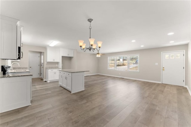 1292 Fernside Dr, Toccoa, GA 30577 - kitchen featuring a chandelier, a kitchen island, light wood-type flooring, white cabinetry, and recessed lighting