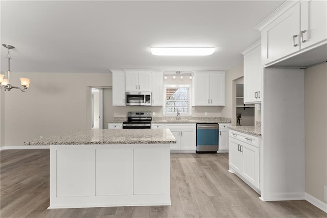 1292 Fernside Dr, Toccoa, GA 30577 - kitchen with stainless steel appliances, a sink, a chandelier, white cabinets, and light wood finished floors