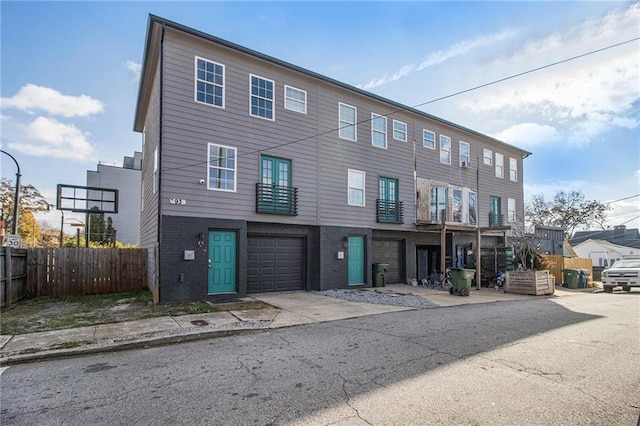 townhome / multi-family property featuring fence and an attached garage