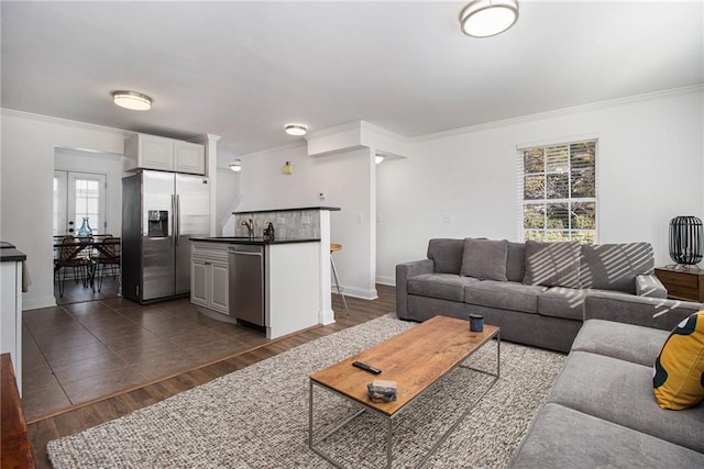 living area featuring baseboards, ornamental molding, and dark wood-style floors